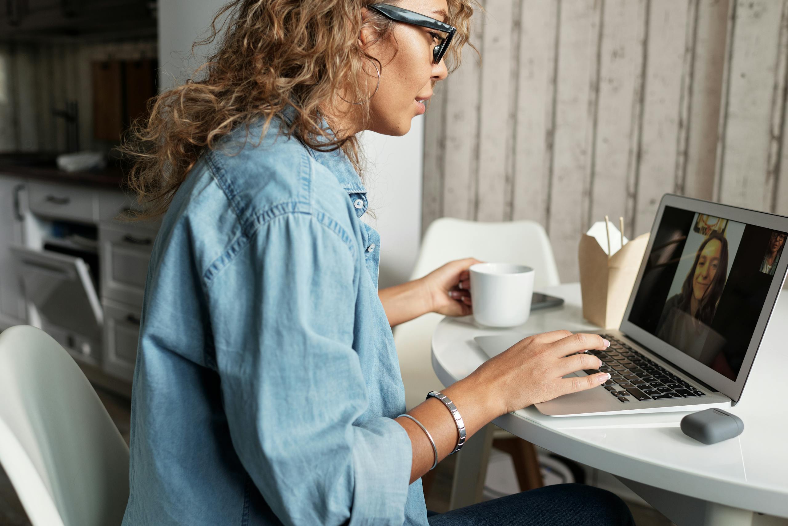 Woman on a video call with coffee.